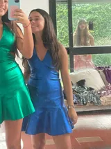 Vestido corto de lentejuelas color verde oliva, con escote en V, breteles finos cruzados en la espalda, cut-outs laterales y volado en el ruedo.