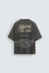 Camiseta gris oscuro con efecto lavado, cuello redondo y manga corta. Tiene un bolsillo en el pecho y estampados en el frente y la espalda.