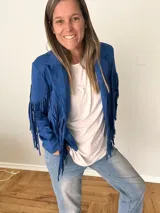 Campera de gamuza sintética color mostaza con flecos largos en mangas y espalda, corte recto con solapas clásicas.