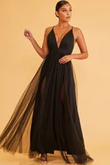 Vestido largo negro de fiesta con escote en V, breteles finos y falda con doble tajo lateral y sobrefalda de tul.