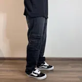 Pantalón jean cargo gris oscuro, corte holgado, con bolsillos laterales y traseros.