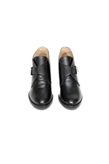 Botas cortas negras de cuero charolado con hebilla plateada y taco medio de 5 cm.