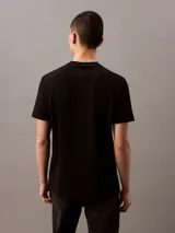 Remera negra de algodón con cuello redondo y logo "Calvin Klein Jeans" estampado en blanco en el frente.