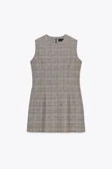 Vestido corto de Zara Woman Collection con estampado a cuadros en tonos grises, cuello redondo y sin mangas. Cierre trasero con cremallera oculta.