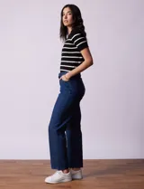 Jean elastizado de corte recto, color azul denim, con pretina con pasadores, botón y cierre. Tiene tres bolsillos delanteros y dos bolsillos traseros.