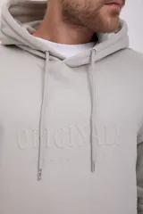 Hoodie tipo canguro color gris mineral, de manga larga con capucha y fit regular. Cuenta con un bolsillo y estampado de goma con tacto suave. Tejido Loop Back.