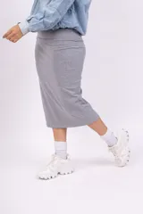 Pollera midi gris de tejido de punto acanalado, corte al cuerpo y cintura alta.