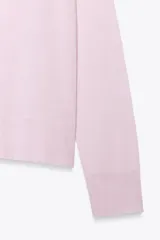 Jersey de punto color borgoña, con cuello redondo, manga larga y bajo con aberturas laterales.