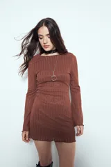 Vestido corto de manga larga acampanada, color marrón óxido, con textura acanalada y terminación ondulada en el ruedo.