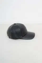 Gorra de béisbol negra de cuero sintético con hebilla metálica ajustable en la parte posterior.