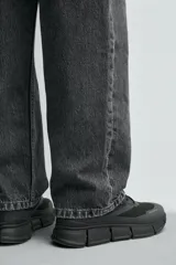 Zapatillas deportivas negras con capellada de tejido técnico transpirable y suela gruesa.