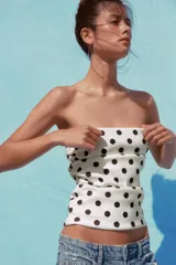 Top blanco con estampado de lunares negros, escote recto, hombros descubiertos y detalle de frunces.
