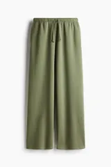 Pantalón de jogging verde oliva, de corte amplio, con cintura elástica ajustable con cordón y bolsillos laterales.