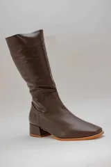 Bota de caña alta de cuero color rojo, con cierre lateral y taco cuadrado de 4 cm.