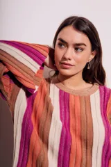 Sweater de punto con rayas verticales en tonos beige, naranja, marrón y fucsia.