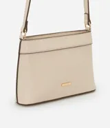 Cartera bandolera pequeña color crema, confeccionada en material sintético con cierre de cremallera y asa larga regulable.