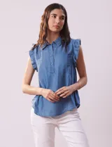 Blusa celeste de lyocell con cuello camisero, abertura con botones y volados en las sisas.