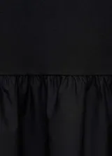 Vestido negro de punto con cuello redondo, corte evasé, detalles fruncidos y largo midi. Confeccionado en tejido combinado de algodón y elastano, con mangas largas.