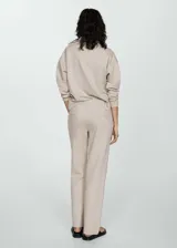 Pantalón de vestir color beige, de corte recto y tiro alto. Presenta cintura elastizada y bolsillos laterales.