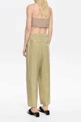 Pantalón largo fluido color beige, con estampado animal print.