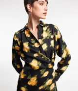 Vestido midi de tejido satinado negro con estampado floral amarillo, cuello solapa, manga larga, abotonado delantero y cruzado lateral.