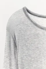 Camiseta entallada gris de manga larga, confeccionada en hilatura con algodón y cuello redondo.