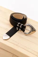 Cinturón negro de cuero sintético con hebilla plateada de estilo western y apliques metálicos plateados.