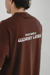 Remera marrón de algodón con cuello redondo y estampado frontal con el logo de la marca Pulau y la frase "Wear More & Worryless".