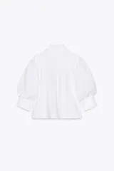Camisa rosada de popelina de algodón, con cuello clásico, manga corta abullonada y cierre frontal con botones.
