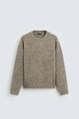 Jersey de hombre color beige con textura bouclé, cuello redondo y manga larga.