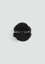 Pinza para el pelo negra con forma de flor texturizada.