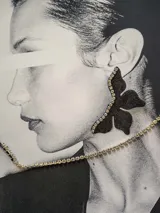 Aros negros con forma de flor y detalle de strass en el borde.