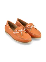 Mocasín color naranja de cuero texturizado, con costuras a la vista y lazo decorativo en la parte delantera.