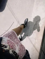 Botas cortas negras de cuero con bordados blancos estilo cowboy.