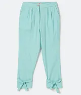 Pantalón zanahoria color celeste pastel, de lino, con pliegues en la cintura, bolsillos delanteros y amarre en la barra.