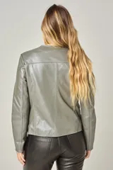 Campera de cuero color natural, con cuello redondo, cierre frontal con cremallera y bolsillos laterales con cierre. Diseño clásico y corte entallado.