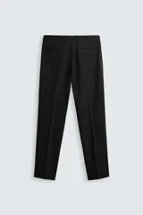 Pantalón de vestir azul marino, de corte slim fit, con bolsillos laterales y traseros. Se ajusta a la cintura con cinturón de cuero marrón.