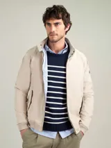 Cazadora tipo bomber color beige, con cierre frontal y bolsillos de solapa.