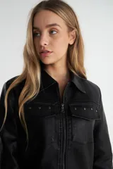 Campera negra de simil cuero con cierre central, cuello clásico y dos bolsillos con solapa en el pecho.