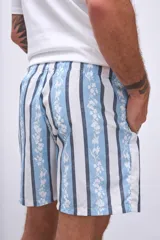 Short de baño celeste con estampado de flores rojas y hojas verdes.