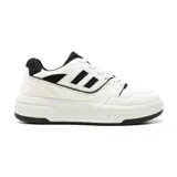 Championes deportivos de hombre, estilo retro/skater, color blanco con detalles en negro. Presentan una silueta robusta con plataforma gruesa y logo lateral de dos franjas negras paralelas.