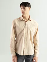 Camisa de manga larga color verde oliva, confeccionada en algodón. Tiene corte clásico, bolsillo en el lado izquierdo del pecho y cierre con botones.