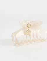 Broche para el pelo tipo pinza, color crema con efecto marmolado y charm colgante dorado con forma de trébol de cuatro hojas.