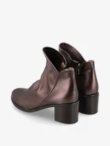 Botín plateado de cuero italiano con diseño moderno y silueta estilizada. Su taco ancho brinda estabilidad y comodidad, mientras que el corte limpio realza la elegancia del modelo.