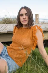 Musculosa color ladrillo de tejido calado con flecos en los hombros y cuello redondo.
