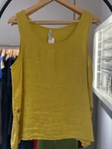 Musculosa sin mangas de lino color mostaza, con escote redondo y aberturas laterales ajustables con botones marrones.