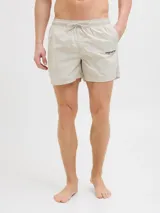 Short de baño color beige con cintura elástica ajustable con cordón, bolsillos laterales y logo de Originals Studio estampado en la pierna.