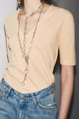 Camiseta color beige de lino con cuello en V y mangas cortas.