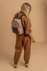 Mochila urbana color gris con detalles en cuero sintético negro. Cuenta con un compartimento principal amplio y un bolsillo frontal con cierre.