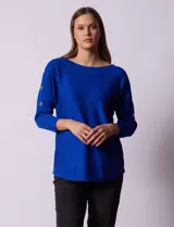 Buzo azul tejido en hilado fino, marca Cable & Gauge. Escote redondo con calados. Manga ¾, modelo dolman. Mangas con aplique de botones.